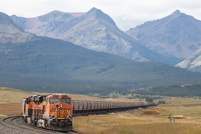 A grain train travels near a mountain pass. A grain train travels near a mountain pass.